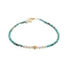 Beaded bracelet with turquoise, white, and gold beads on a white background