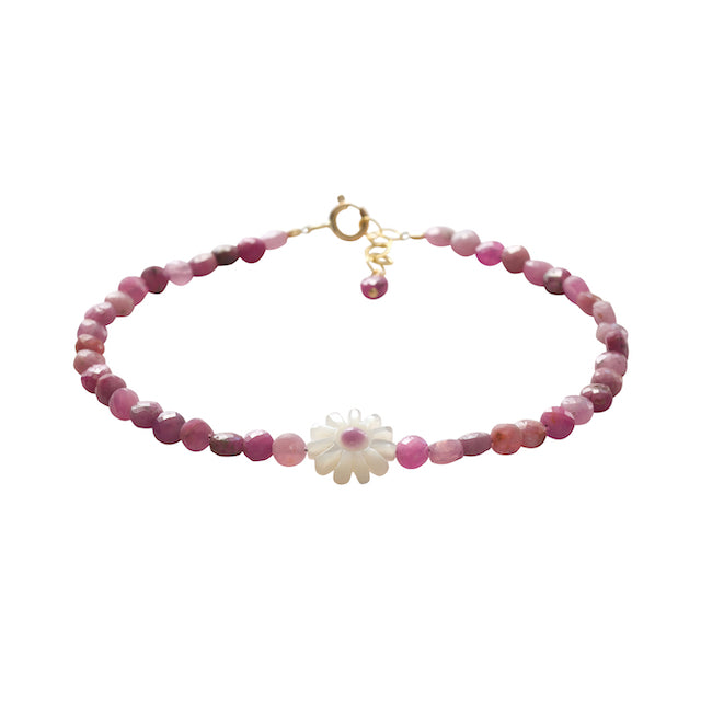 Pink roby beaded bracelet with a white flower charm on a white background