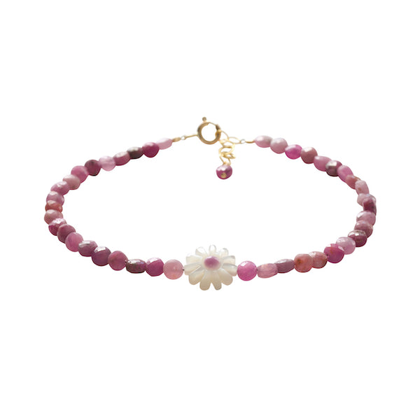 Pink roby beaded bracelet with a white flower charm on a white background