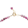 Bracelet with pink beads and gold clasp on a white background