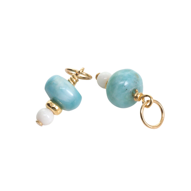 Pair of earrings with turquoise and white beads on a white background