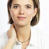 Woman wearing a necklace with a plain white background