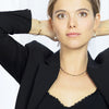 Woman wearing a black blazer with jewelry on a white background