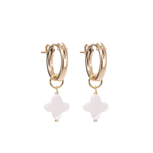 Gold hoop earrings with white flower-shaped charms on a white background