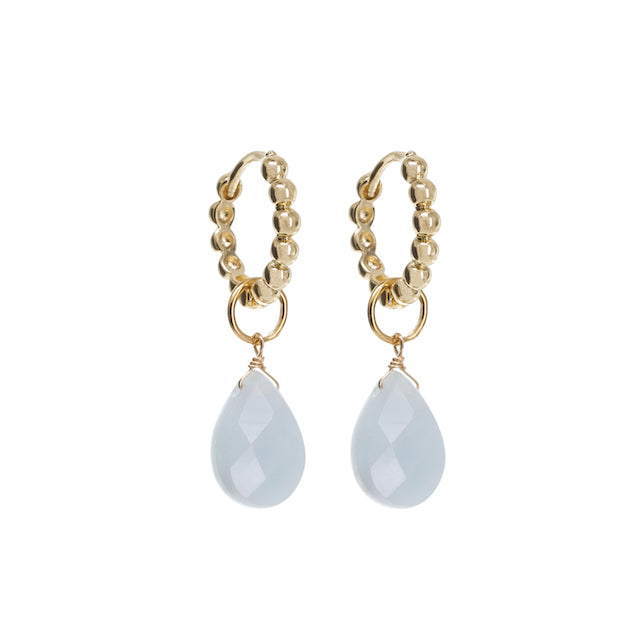 Gold hoop earrings with teardrop-shaped gemstones on a white background